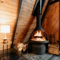 a wood burning stove inside of a wooden cabin
