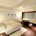 A bedroom with a large bed and wooden floors