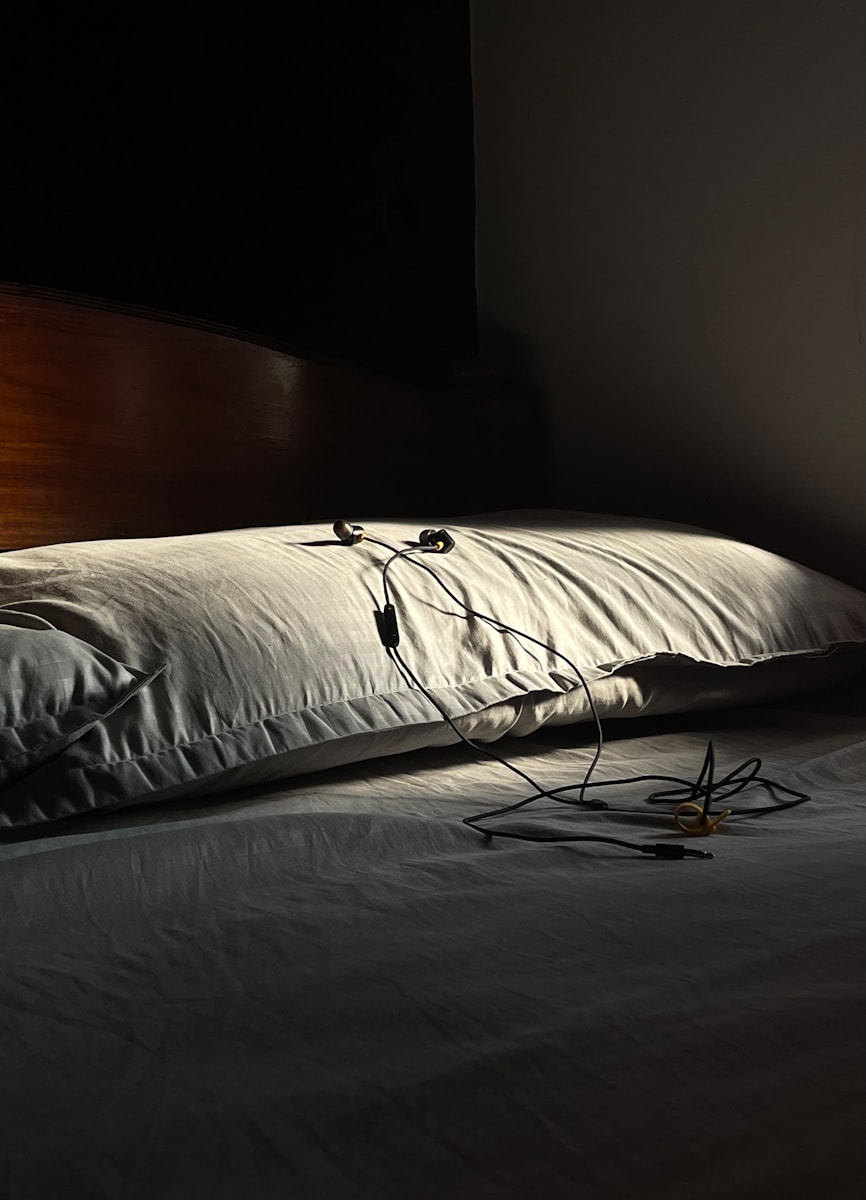 a bed with a white comforter and a wooden headboard